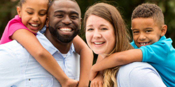 man; woman and two children smiling